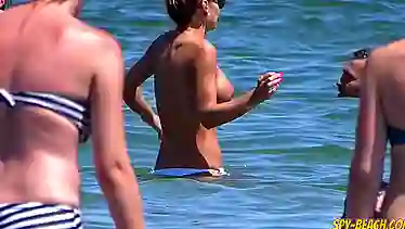 Watch these hot babes flaunt their big tits and get naughty in public with topless beach action!